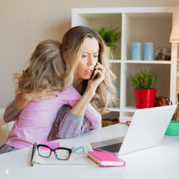 Busy mom huging kid and on the phone and using a laptop at the same time.