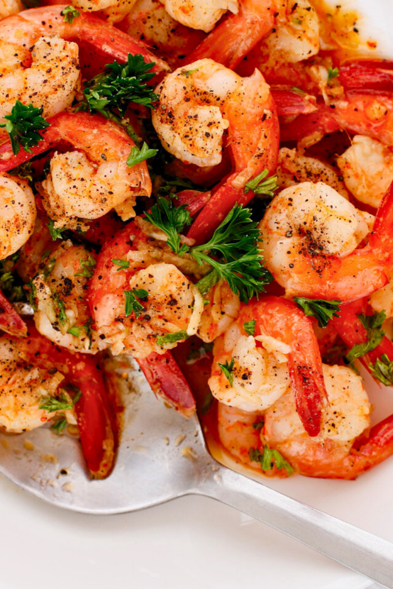 Puerto Rican garlic shrimp (camarones al ajillo) made with sautéed shrimp, fresh garlic, red peppers, parsley, and black pepper in a light garlic butter white wine sauce, close-up seafood dinner.