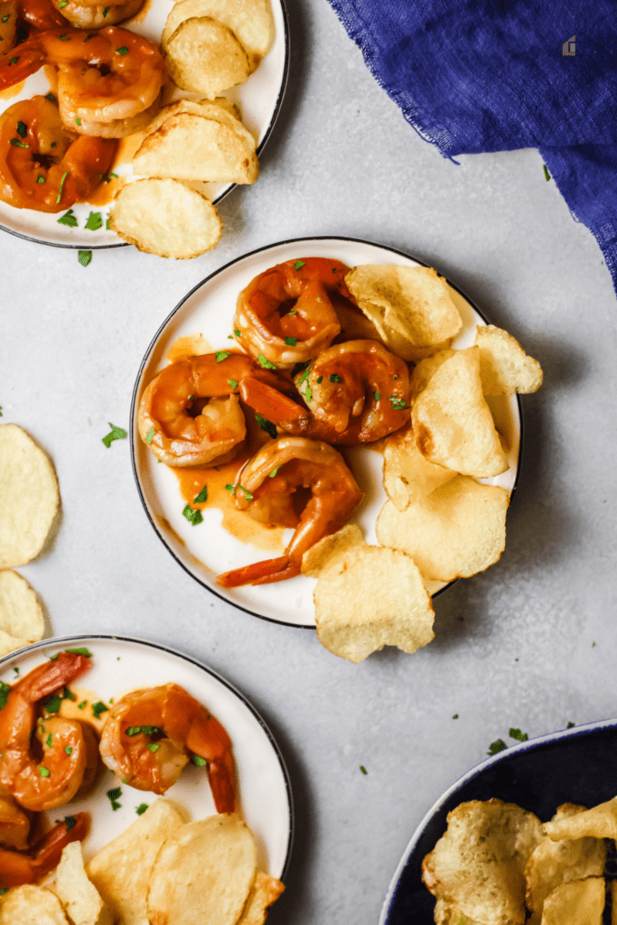 Plated camarones al ajillo with chips on the side.