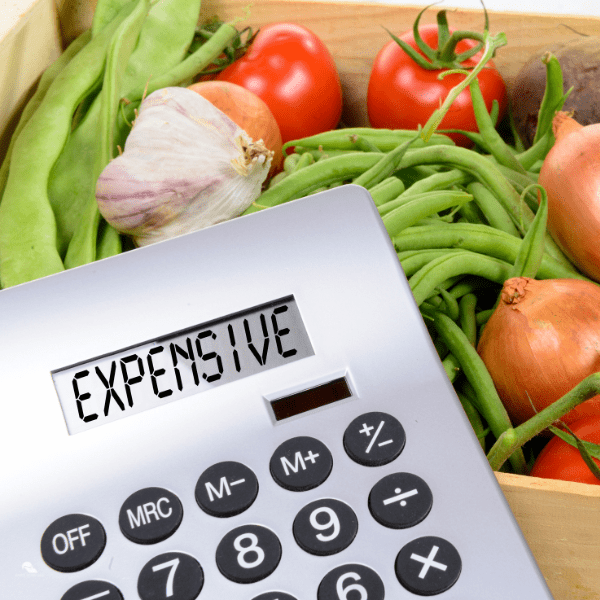 Box of vegetable with calculator that reads expensive.