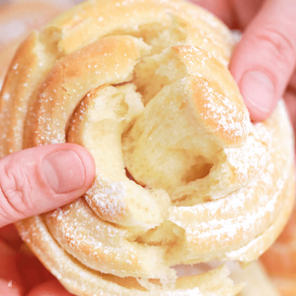 Close ip of mallorca bread being pulled apart showing soft inside.