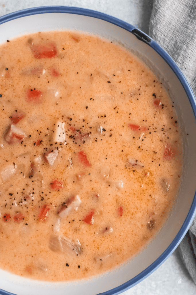 ham potato soup served in white bowl.
