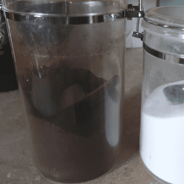 Coffee in a plastic container on top of a kitchen counter.