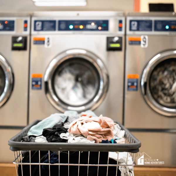 Thrift clothes in a laundry box in front of a laundry machine