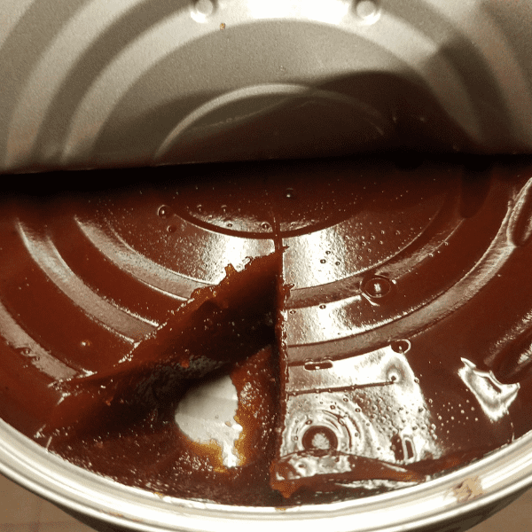 Guava paste in a metal container with a piece missing.