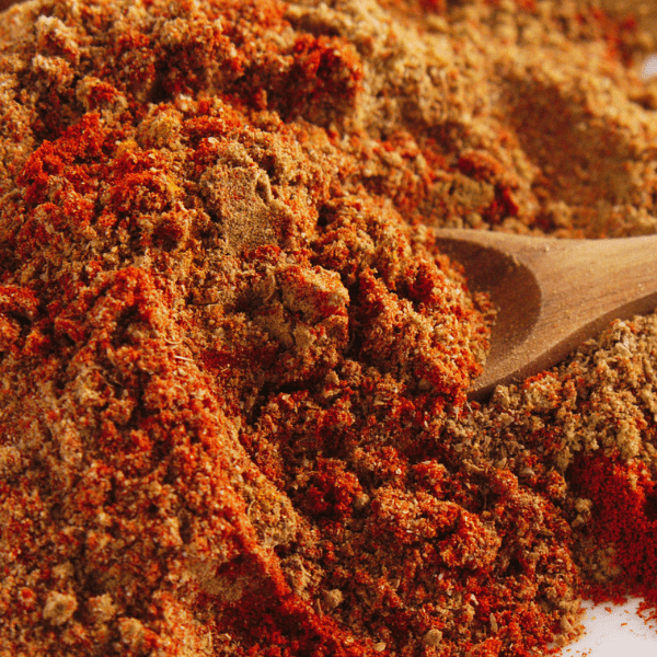 Close up of blended seasoning with a wooden spoon on the side.