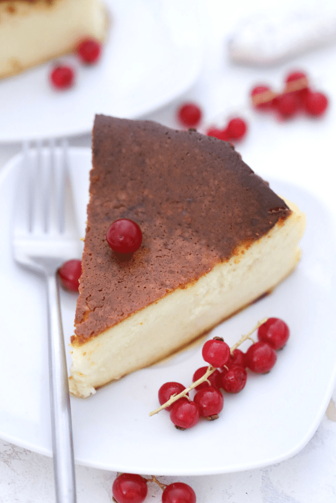 A slice of basque cheesecake plated with berries on the side.