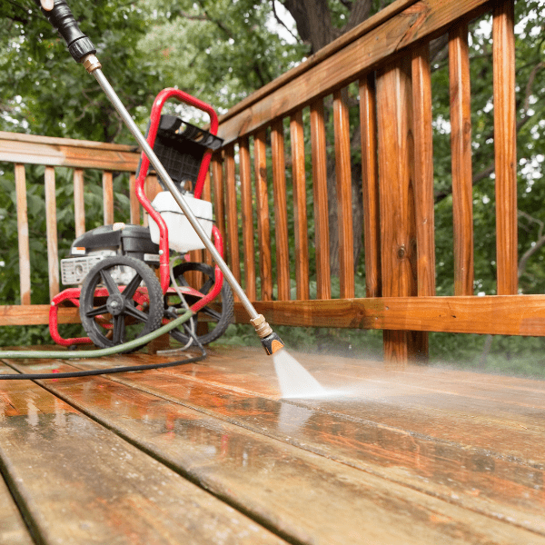 Pressure washer cleaning a weathered deck.