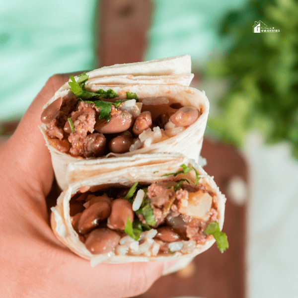 A man holding two Mexican Burritos