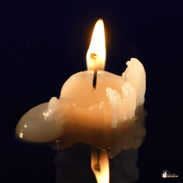An image of a burning candle with melted wax on the sides.