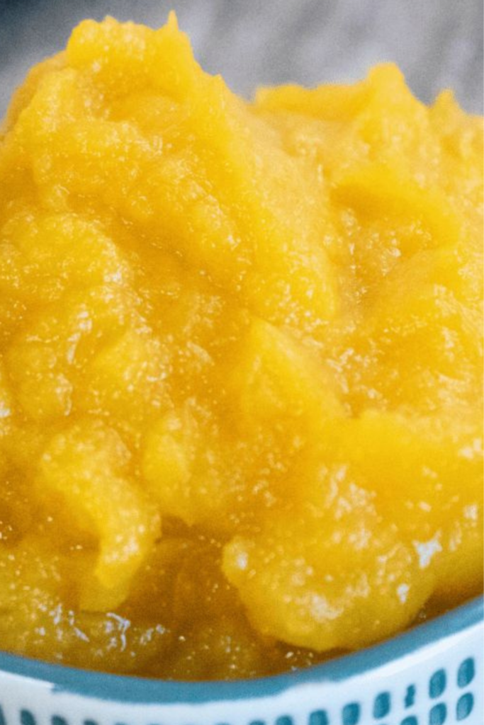Thick and vibrant pumpkin puree in a blue and white bowl, ready for use in recipes.