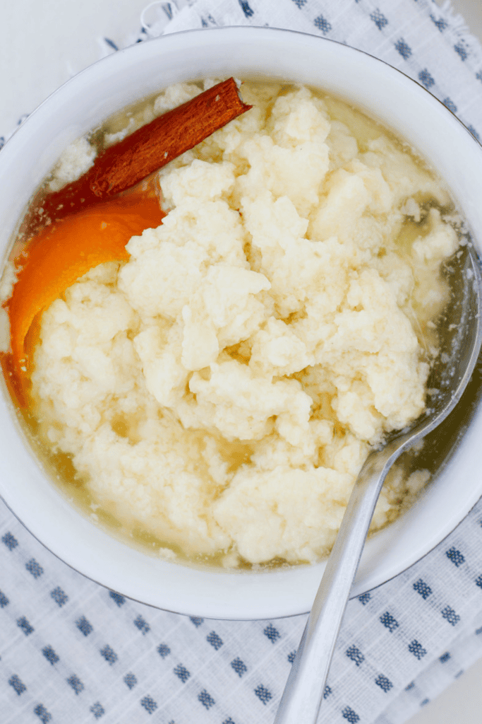 Creamy dulce de leche cortada served in a white bowl with sweet milk curds, cinnamon stick, orange peel, and light syrup. Traditional Puerto Rican dessert also known as miguelucho.