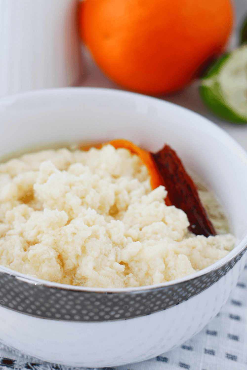 Close-up of creamy dulce de leche cortada in a white bowl with soft sweet milk curds, cinnamon stick, and orange peel. Traditional Puerto Rican dessert recipe also known as miguelucho.