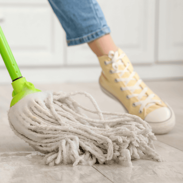 Woman mopping floor in kitchen.