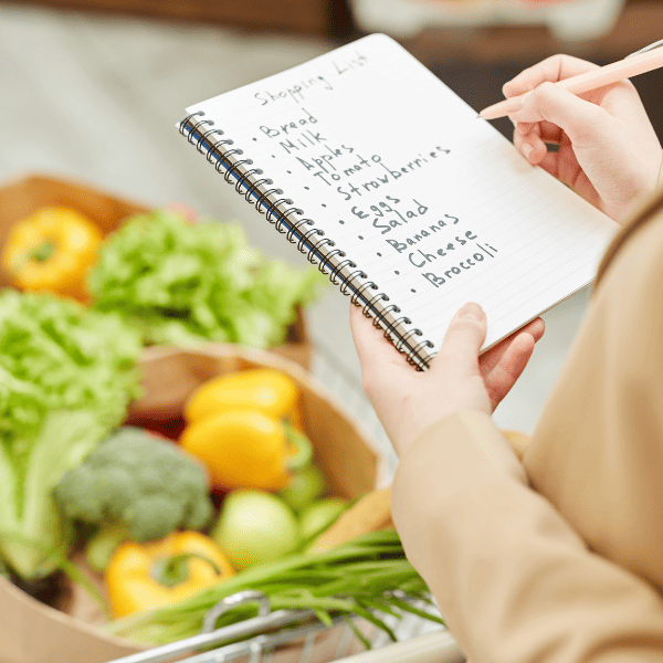 Closeup of woman holding a shopping list while buying groceries.