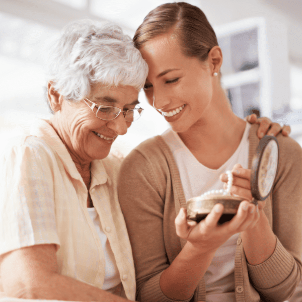 Senior woman giving pearlnecklace  to her daugther.