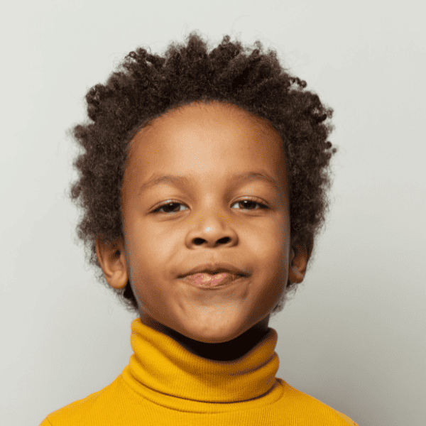 Black little boy smiling at camera.