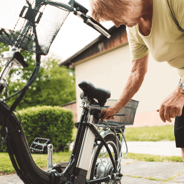 Older woman preparing her electric bike outdoors.