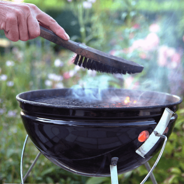 Man cleaning a grill in the garden.