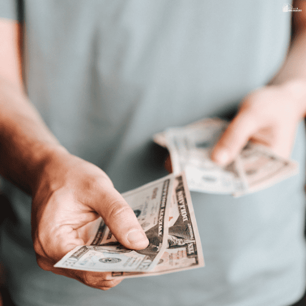 A person counting cash by hand while reviewing available money and making careful spending decisions during financial hardship.