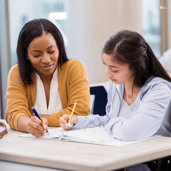 a teen being tutored by a lady in a table