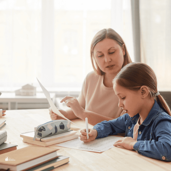 a girl writing at home with mother