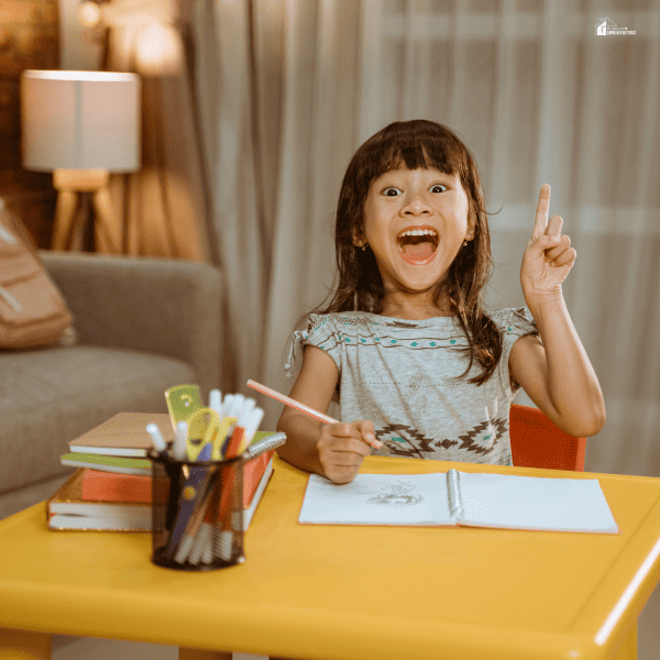 a girl happily holding a pencil