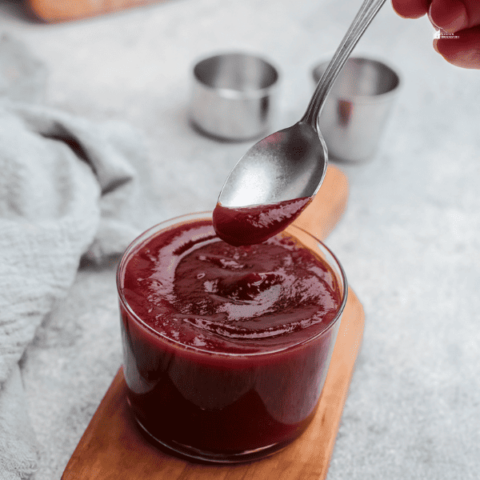 an image of someone holding a spoon over a cup Homemade BBQ Sauce