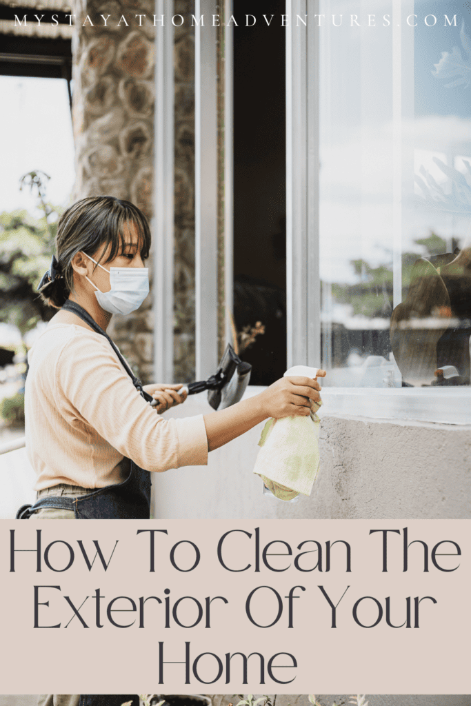 an image of a lady cleaning the exterior of the windows in a house