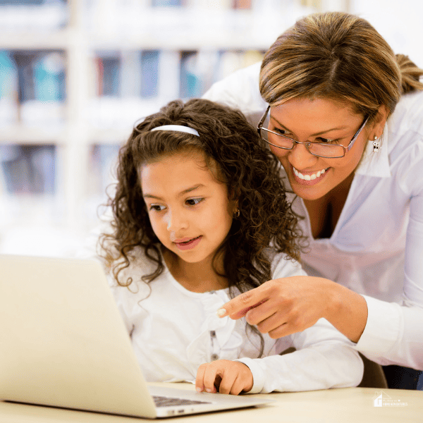 schoolgirl researching online with the guidance of her mom