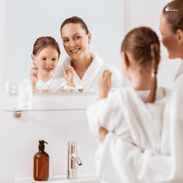 mom and daughter flossing their teeth