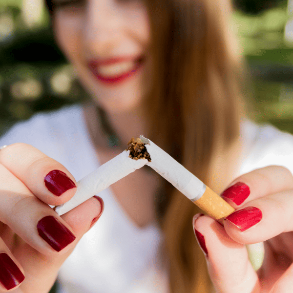 Smilling woman breaking a cigarette.