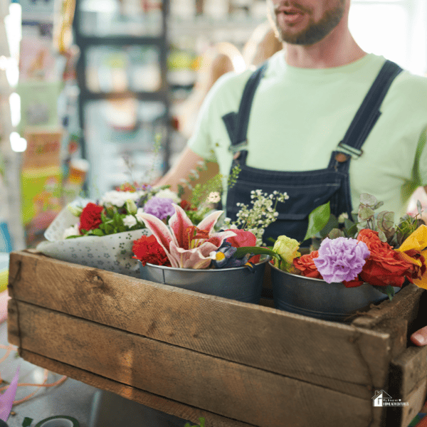 man holding a wooden box with flowers