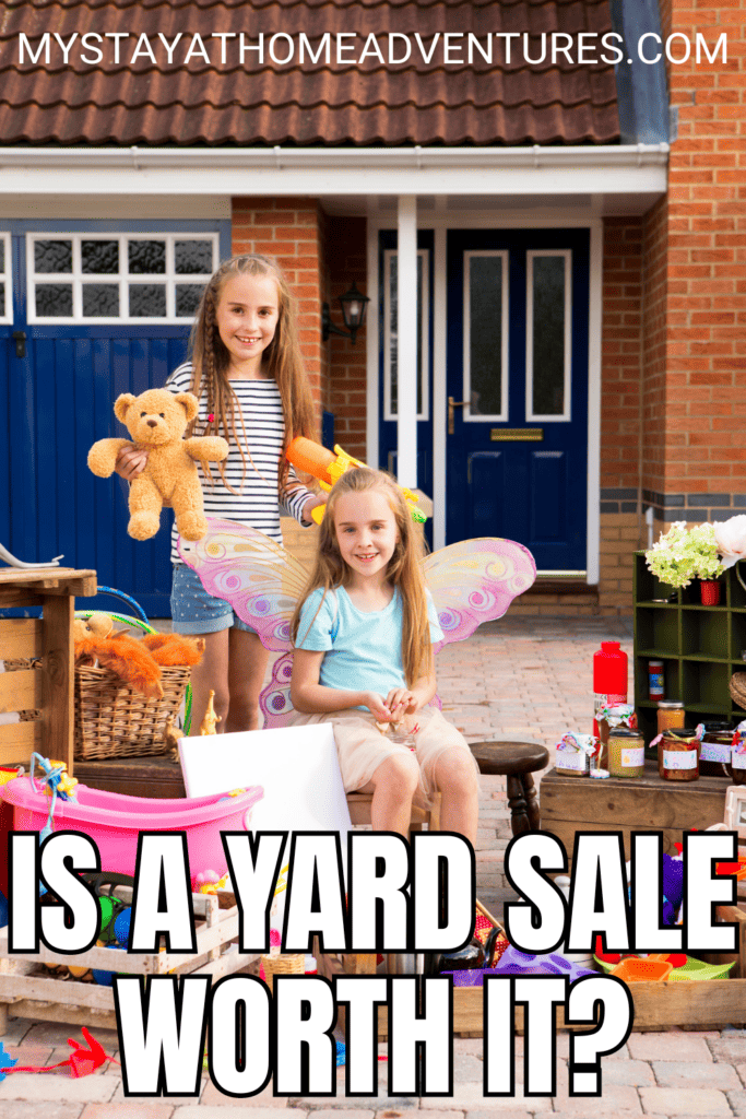 two sisters hold some old toys as they sit on a driveway for a yard sale with text: "Is a Yard Sale Worth It?"