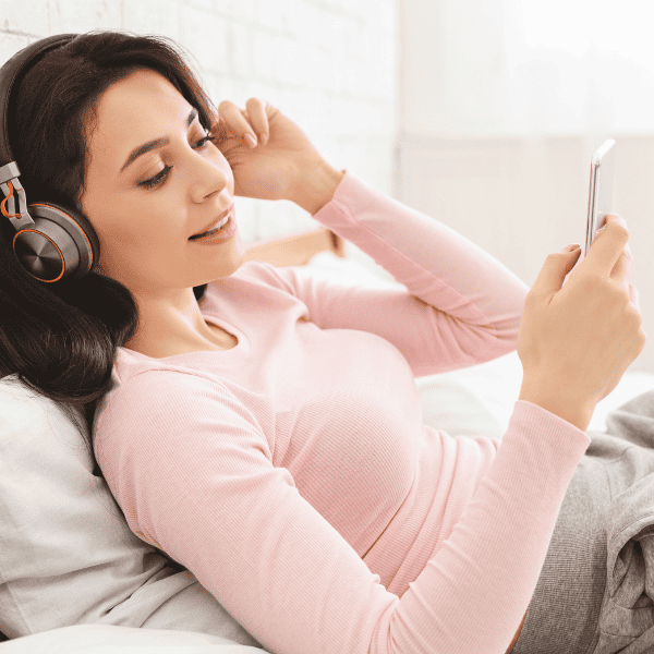 woman listening to audiobook in bed