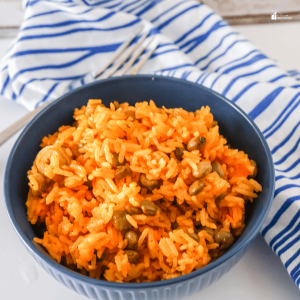 an image of Arroz Con Grandules in a blue bowl overvuew