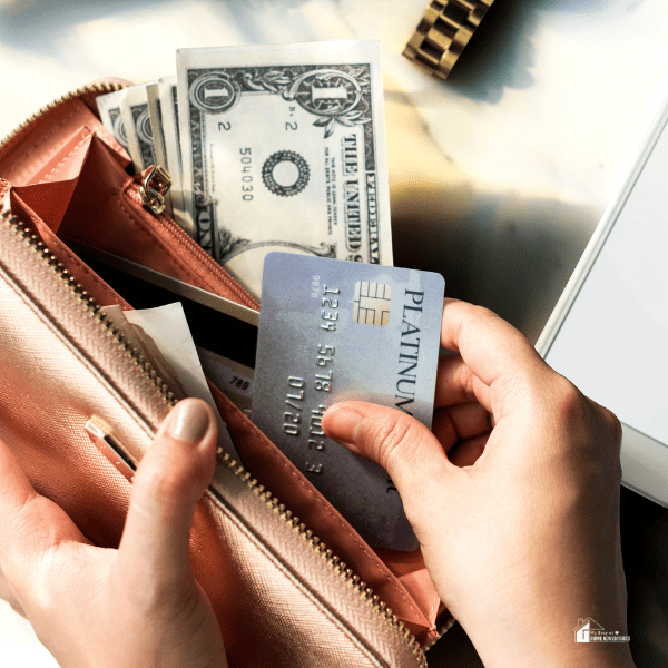 a woman holding a wallet with cash and card