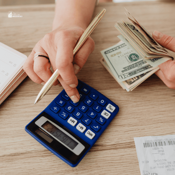 a woman calculating expenses while holding a pencil and a few cash