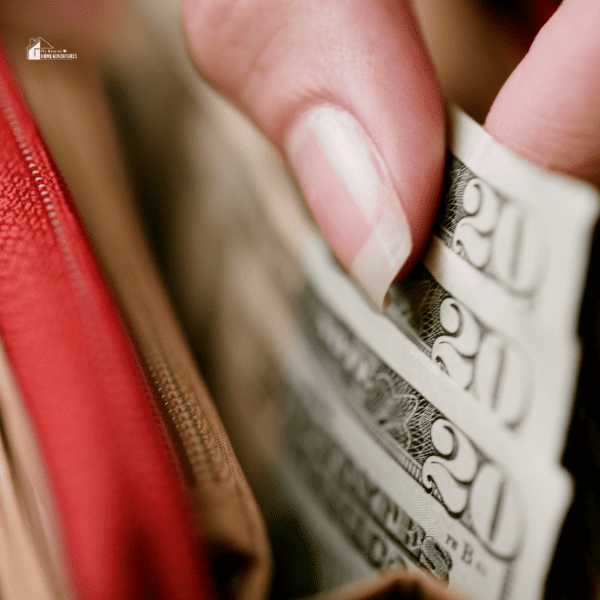 a close up image of a woman holding a few cash from her red wallet