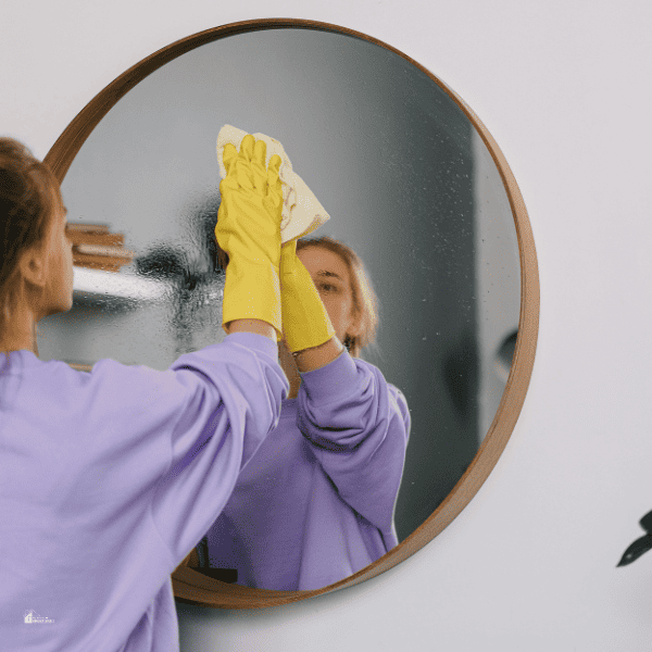 Woman Wearing Glove Cleaning a Mirror