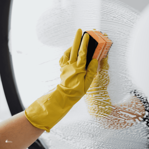 Faceless person cleaning mirror with sponge