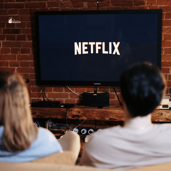 Man and Woman Sitting on a Couch in Front of a Television with Netflix subscription