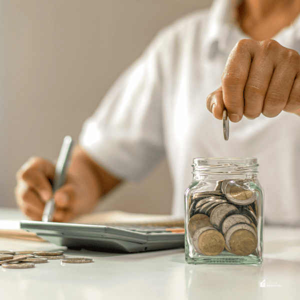 Person Saving Coins in a Jar