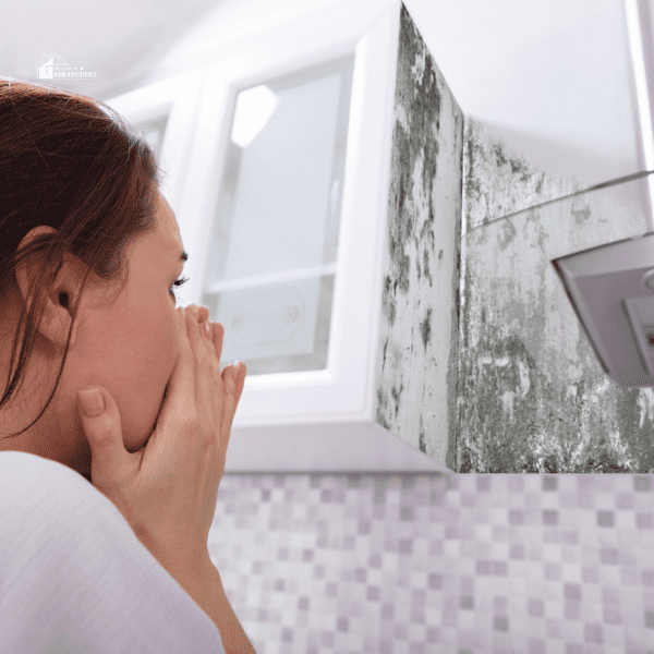 Woman Looking At Mold On Wall in a bathroom