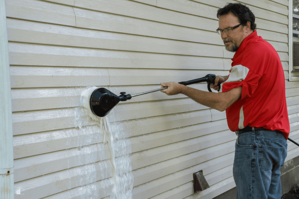 Contractor Using A High Pressure Brush To Remove Algae And Mold