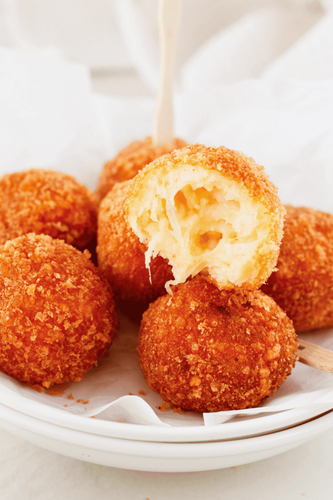 Puerto Rican bolitas de queso with a crispy golden breadcrumb coating and gooey melted cheese center.