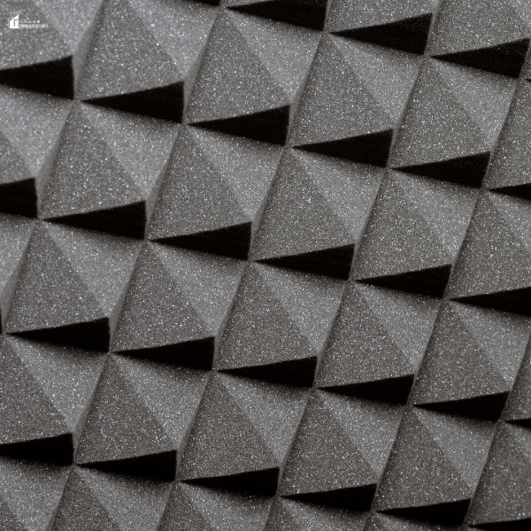 Textured black acoustic foam panels arranged in a pyramid pattern for sound absorption.