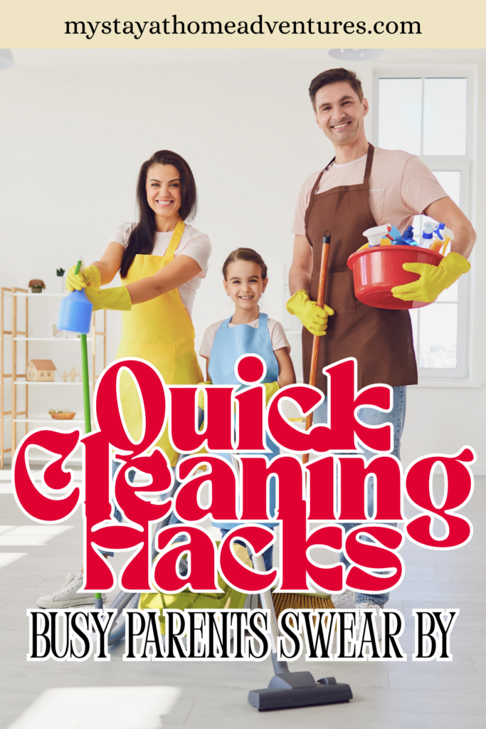 A smiling family wearing cleaning gloves and aprons stands in a bright room with cleaning supplies, ready to clean together.
