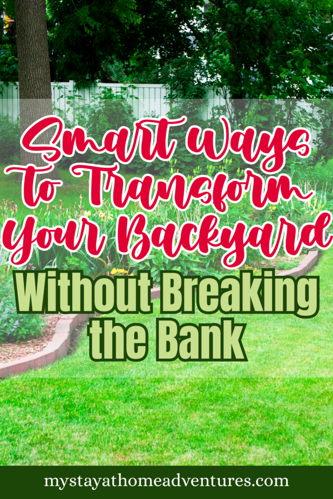 A neatly maintained backyard with lush green grass, garden beds, and a curved stone border with blooming plants.