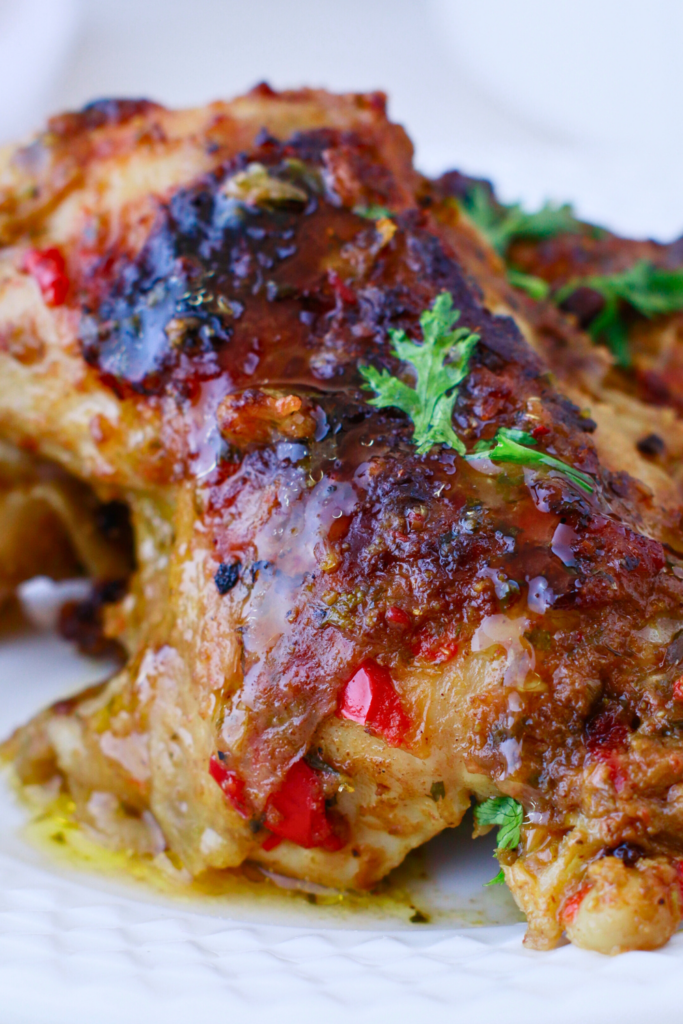 Close-up of juicy Puerto Rican baked chicken (pollo al horno) with crispy skin, marinated in sofrito and spices, perfect for a flavorful Caribbean dinner.